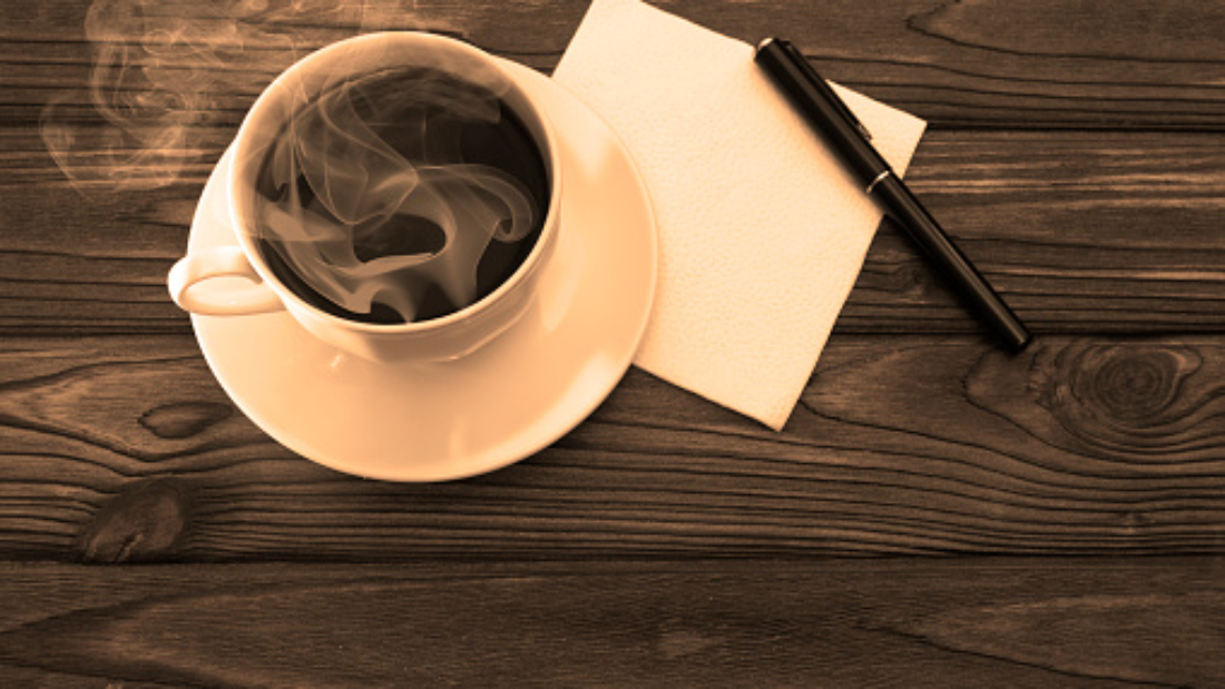 Cup of coffee, napkin, pen on wooden table background. coffee-break.