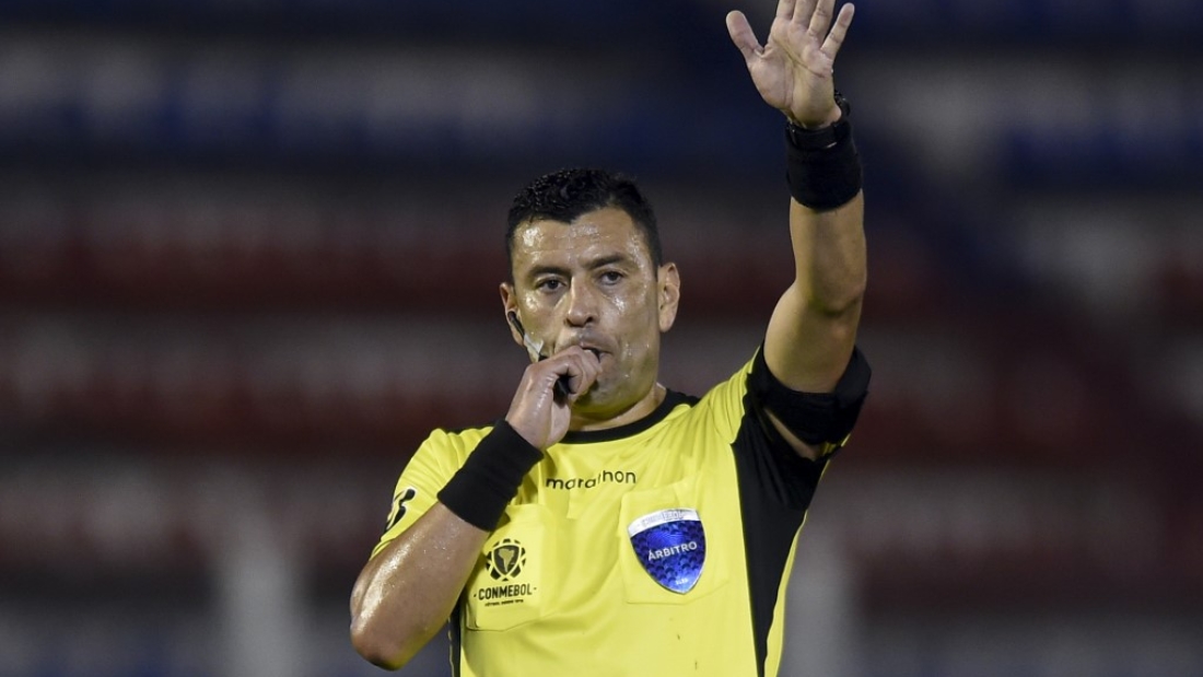 Chilean referee Roberto Tobar blows the whistle as he conducts the closed-door Copa Libertadores group phase football match between Argentina's Tigre and Bolivia's Bolivar at the CA Tigre stadium in Tigre, Argentina, on September 22, 2020, amid the COVID-19 novel coronavirus pandemic. (Photo by Marcelo Endelli / POOL / AFP)