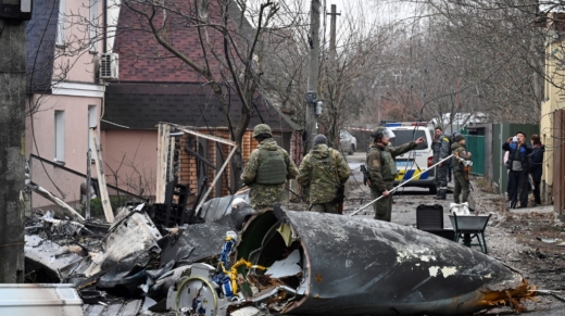 Ukrainian servicemen work by the wreckage of an unidentified aircraft which crashed into a  private house in a residential area in Kyiv on February 25, 2022. - Russian forces reached the outskirts of Kyiv on Friday as Ukrainian President Volodymyr Zelensky said the invading troops were targeting civilians and explosions could be heard in the besieged capital. Pre-dawn blasts in Kyiv set off a second day of violence after Russian President Vladimir Putin defied Western warnings to unleash a full-scale ground invasion and air assault on Thursday that quickly claimed dozens of lives and displaced at least 100,000 people. (Photo by GENYA SAVILOV / AFP)